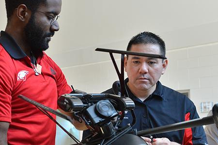 Engineering student and faculty holding a drone